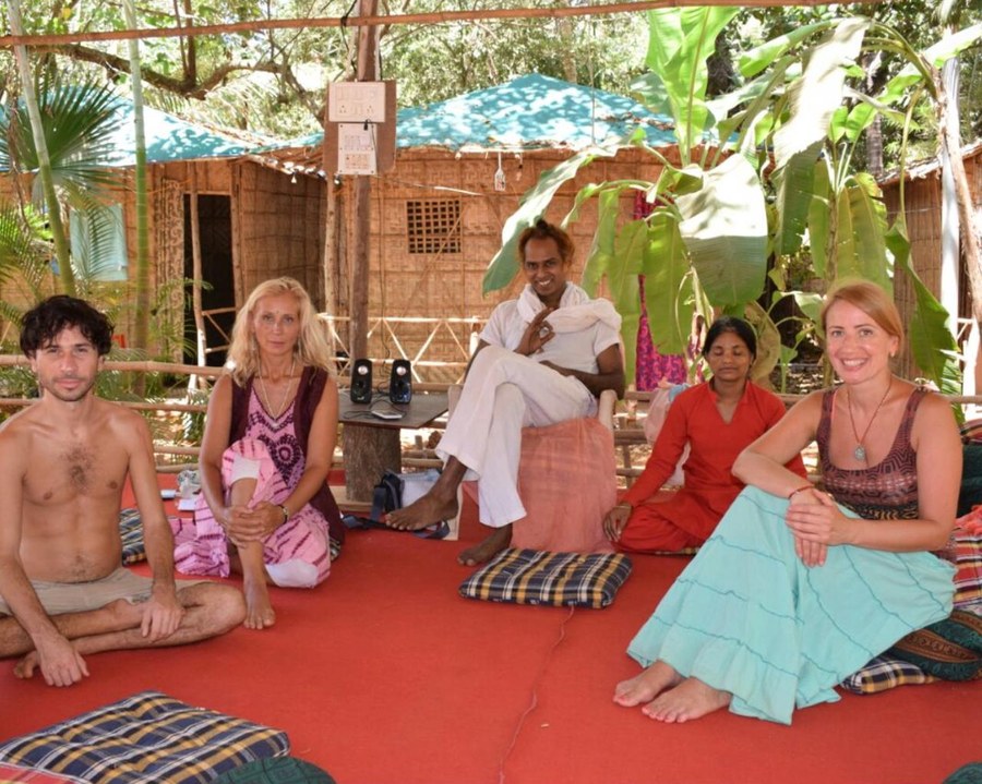Ramabuddha seated with a small group in an open bamboo space, sharing practice